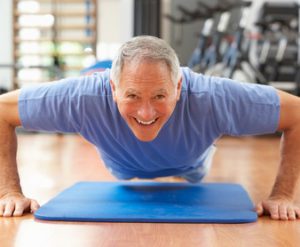 Senior Man Doing Press Ups In Gym